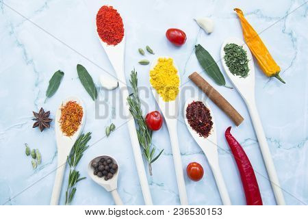 Cooking Hot Spicy Food Concept. Dry Spices And Herbs In Wooden Spoons, Fresh Herbs, Chili Peppers An