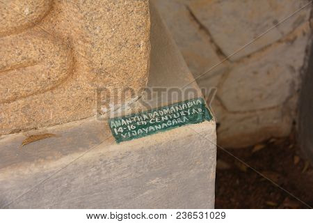 A Sign With A Sculpture In The Hampi Museum. Buddha Stone Lies In The Open-air Museum In Hampi, Indi