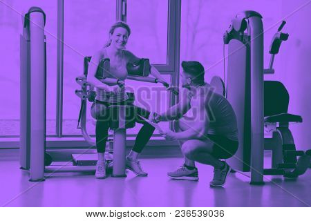 Gym woman exercising with her personal trainer duo tone