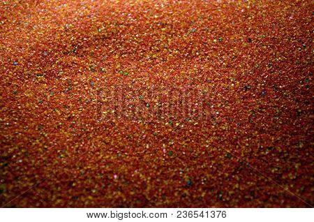 Texture Of A Colored Granular Sand Close Up. Red Grains
