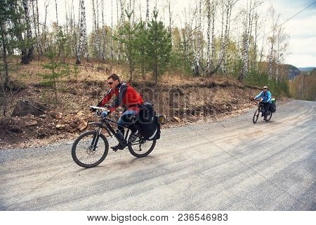 Group Of Tourists In A Hike On Bicycles With Backpacks. Travelers On Bikes. Bicycle Tourism