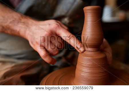 A Male Potter In Plaid Shirt And Dirty Apron Who Molds Bowl From Clay, Selective Focus, Close-up. Cr