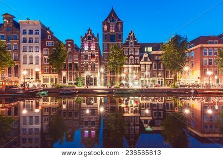 Amsterdam Canal Herengracht With Typical Dutch Houses And Their Reflections During Morning Blue Hour