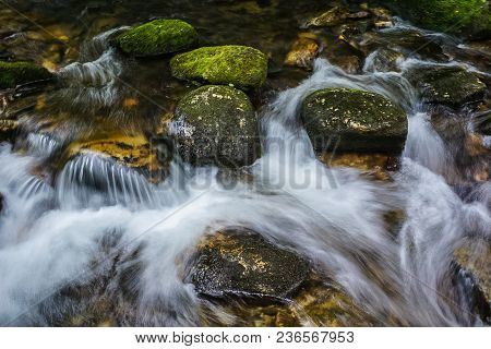 A Scenic Cool Mountain Stream With Moss Covered Rocks