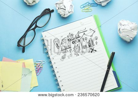 Idea With Plan On Notepad On Blue Background