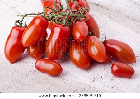 Bunch Of Freshly Picked San Marzano Tomatoes Laid Down On A Light Wooden Table