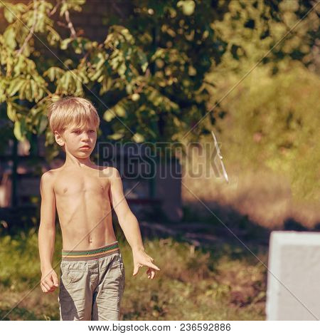 Concentrated Sporty Young Boy Training With Throwing Knife, Image With Toning And Square Aspect Rati