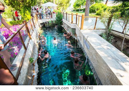 Pammukale, Turkey- July, 2015: Tourists swim in antique Cleopatra pool. Color of water is caused by the presence of a large amount of radon.