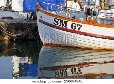 Grisslehamn, Sweden - Jul 08, 2017: Traditional Fishing Boat Reflecting In The Water In The Small Ha