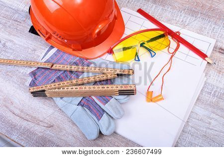 Orange Hard Hat, Earplug, Safety Glasses And Gloves For Work. Earplug To Reduce Noise On A White Bac