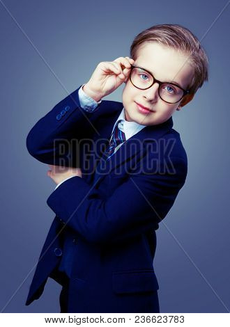 hansome boy wearing glasses and a black suit, isolated against studio background