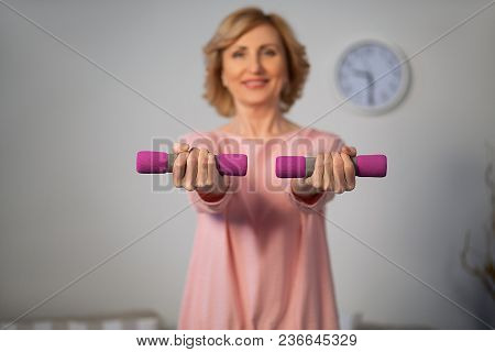 Middle Aged Woman Training With Drumbells At Home. Sport Concept.