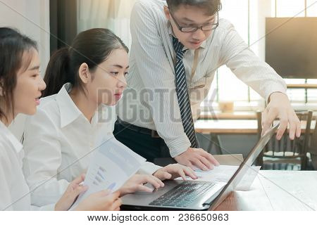 Group Of Young Asian Business People Working Together On A Laptop Computer At Office. Teamwork Brain