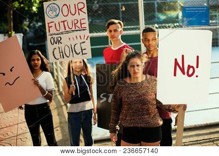 Group of teenagers protesting demonstration holding posters antiwar justice peace concept
