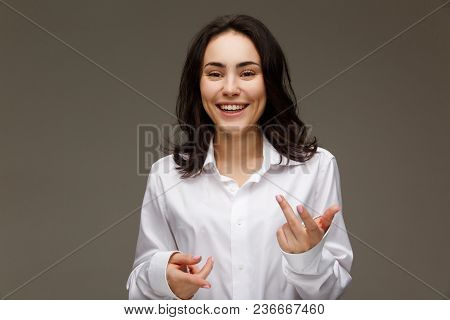 Beautiful Girl In A White Shirt Shows Emotions. On A Light Background.