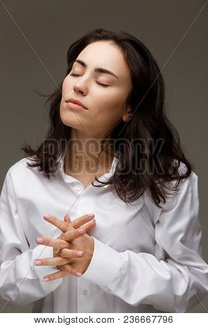 Beautiful Girl In A White Shirt Shows Emotions. On A Light Background.