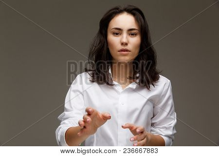 Beautiful Girl In A White Shirt Shows Emotions. On A Light Background.