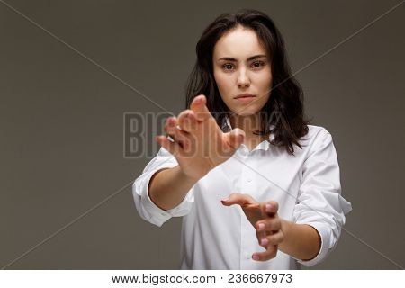 Beautiful Girl In A White Shirt Shows Emotions. On A Light Background.