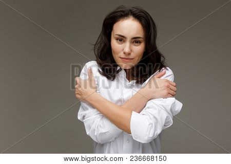Beautiful Girl In A White Shirt Shows Emotions. On A Light Background.