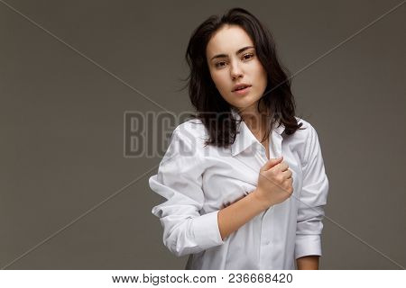 Beautiful Girl In A White Shirt Shows Emotions. On A Light Background.