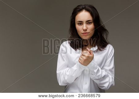 Beautiful Girl In A White Shirt Shows Emotions. On A Light Background.