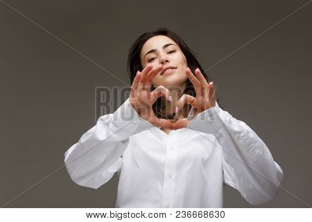 Beautiful Girl In A White Shirt Shows Emotions. On A Light Background.