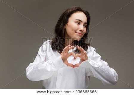 Beautiful Girl In A White Shirt Shows Emotions. On A Light Background.