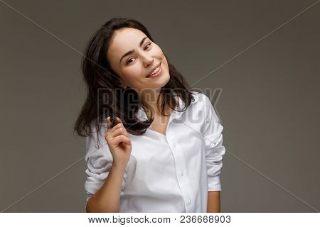 Beautiful Girl In A White Shirt Shows Emotions - Smile, Fun. On A Light Background.