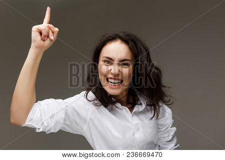 Beautiful Girl In A White Shirt Shows Emotions. On A Light Background.