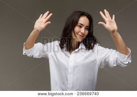 Beautiful Girl In A White Shirt Shows Emotions - Smile, Fun. On A Light Background.