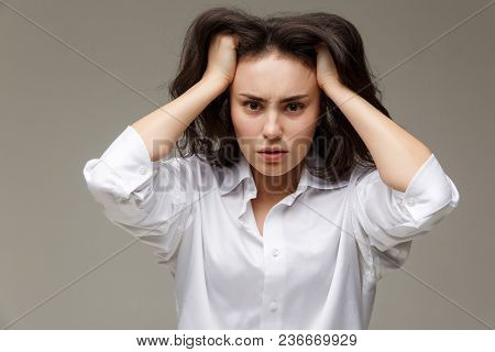 Beautiful Girl In A White Shirt Shows Emotions. On A Light Background.