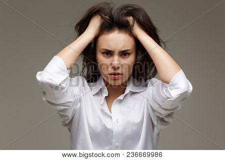 Beautiful Girl In A White Shirt Shows Emotions. On A Light Background.