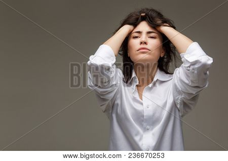 Beautiful Girl In A White Shirt Shows Emotions. On A Light Background.