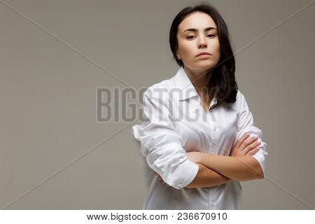 Beautiful Girl In A White Shirt Shows Emotions. On A Light Background.