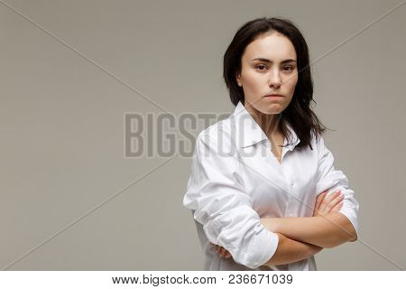 Beautiful Girl In A White Shirt Shows Emotions. On A Light Background.
