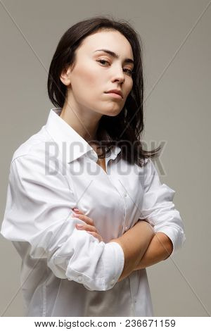 Beautiful Girl In A White Shirt Shows Emotions. On A Light Background.