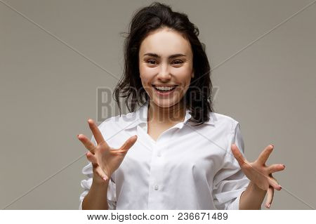 Beautiful Girl In A White Shirt Shows Emotions. On A Light Background.