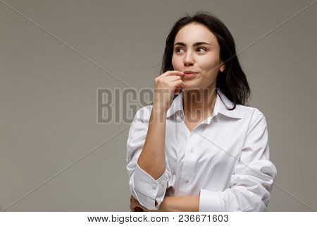 Beautiful Girl In A White Shirt Shows Emotions. On A Light Background.