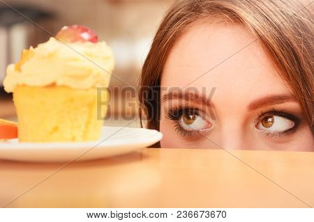Woman Looking At Delicious Cake With Sweet Cream And Fruits On Top. Appetite And Gluttony Concept.