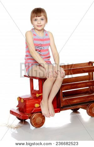Beautiful Little Caucasian Girl With A Short Bangs And Hair Tucked Into A Tail. In Striped In A T-sh