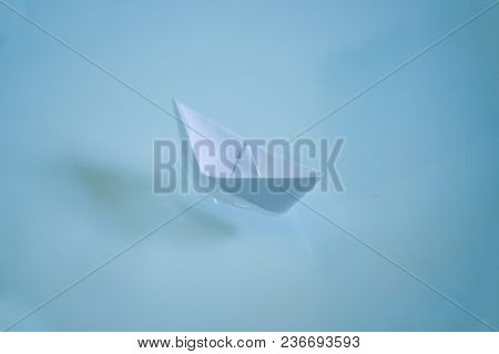 Small Folded Paper Ship On White Water As Symbold For Transportation And Tourism