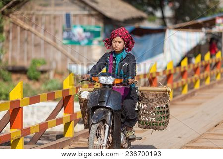 Inle Lake, Myanmar-december 20, 2015. Woman From Tribe Riding Motoroler Loaded With Goods From Sunda