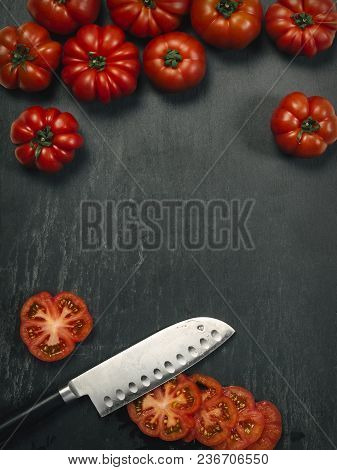 Photo Of A Table Top With Marmande Tomatoes, A Knife, And Slices With Copy Space In The Middle.