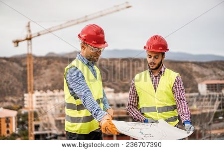 Builders On Residential Construction Site Looking The Building Project  - Workers Are Satisfied Of T