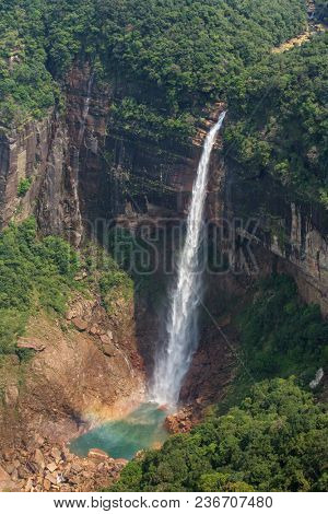 Nohkalikai waterfall surrounded by high cliffs and woodland and thick vegetation near Cherrapunji, Meghalaya, India.