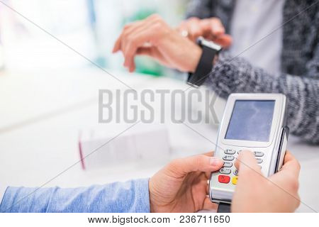 Unrecognizable Pharmacist Serving A Customer. Card Payment.