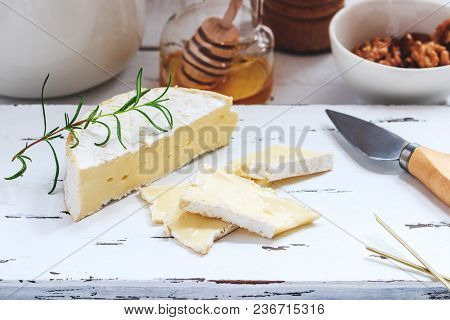 Cheese Plate Served With Crackers, Honey And Nuts. Camembert On White Wood Serving Board Over White 