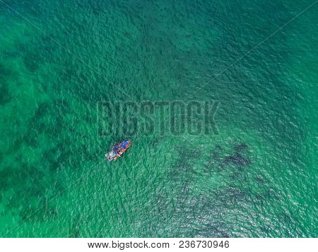 Fishing Boat Floating In The Sea. The Beautiful Bright Blue Water In A Clear Day.aerial View.top Vie