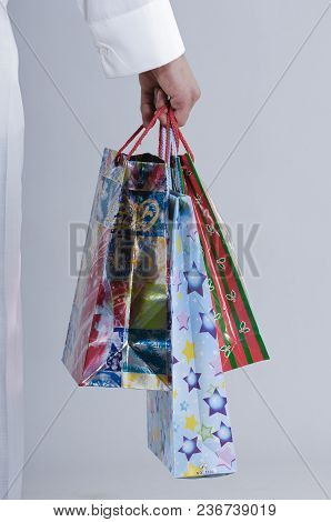 Hand Holding Shopping Bags With Gifts