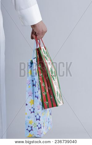 Hand Holding Shopping Bags With Gifts
